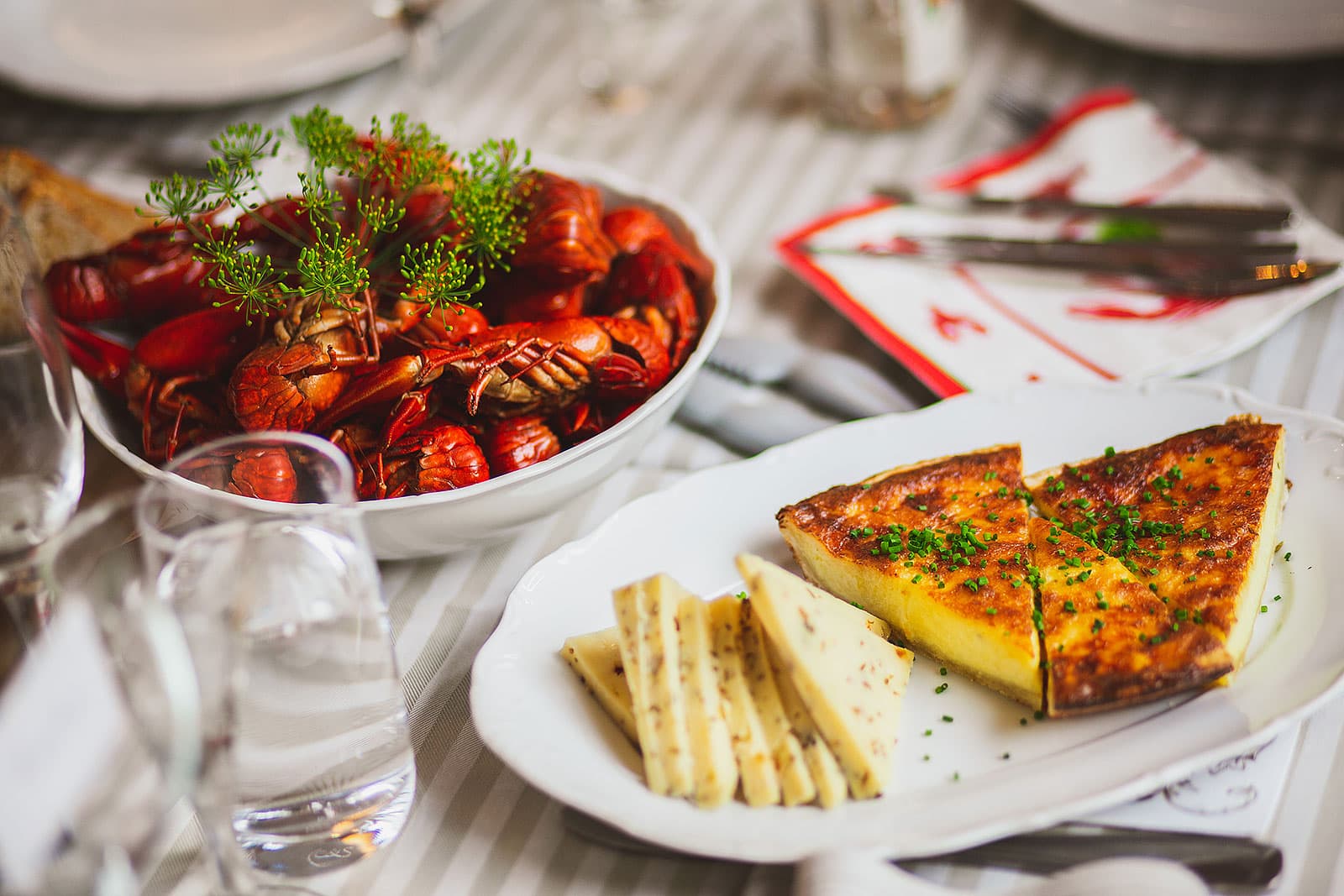 Crayfish bowl with dill flowers next to a slice of cheese pie